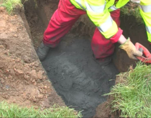 The roadside excavation for a broadband cabinet with two bags of Conducrete in the base
