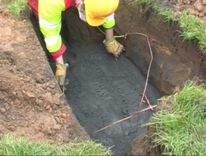 The roadside excavation for a broadband cabinet with Conducrete in the base and 16mm wire earth ring being installed